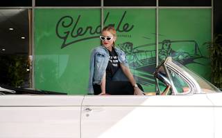 woman in a jean jacket sitting in a white convertible