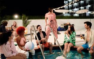 people sitting on the edge of a pool with their feet in the water