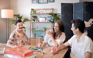 three people sitting around a table laughing