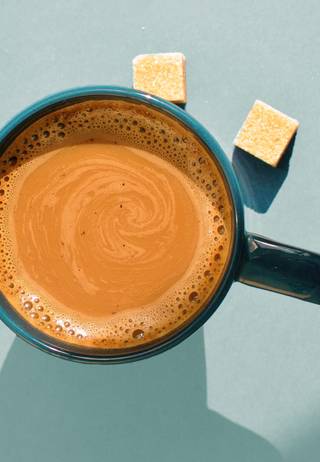 Coffee mug with latte and sugar cubes