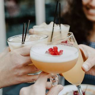 4 fancy drinks being cheersed together