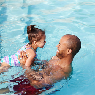 Man and daughter in swimming pool