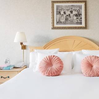 hotel bed with two pink circle pillows