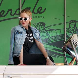 Woman sitting on classic car