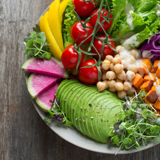 overview shot of table with people's hands over plate of burgers and fries